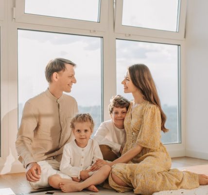 A joyful family sits together in a sunlit living room, fostering warmth and connection.