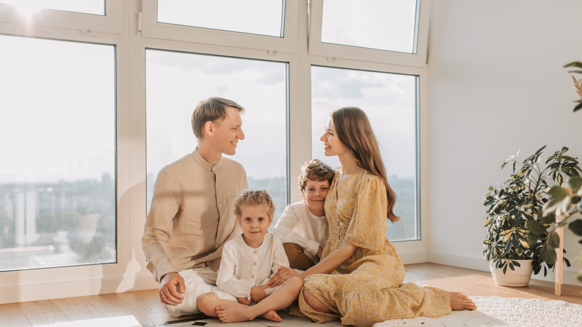 A joyful family sits together in a sunlit living room, fostering warmth and connection.